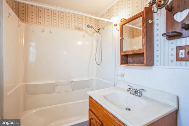 bathroom featuring vanity, crown molding, washtub / shower combination, and wallpapered walls