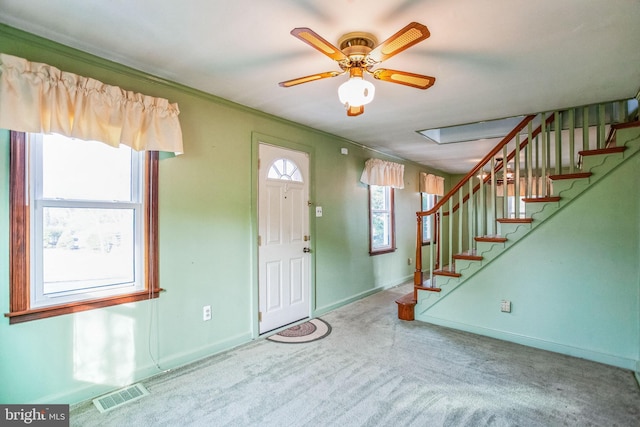 carpeted foyer entrance featuring visible vents, baseboards, a ceiling fan, and stairway