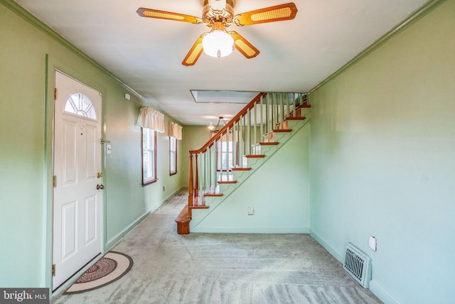 foyer with visible vents, ornamental molding, carpet floors, baseboards, and stairs