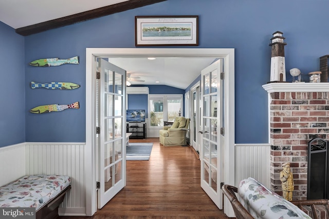 hall with french doors, wood finished floors, wainscoting, and vaulted ceiling