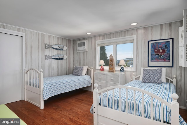 bedroom with recessed lighting, wood finished floors, and a wall mounted AC