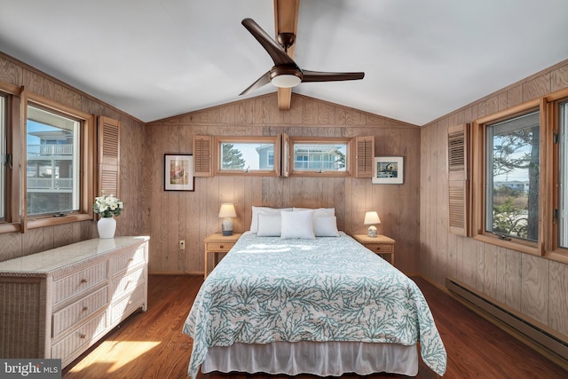 bedroom featuring baseboard heating, wood finished floors, wooden walls, and vaulted ceiling