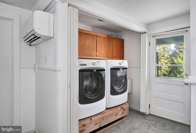 laundry room with washer and clothes dryer, cabinet space, and an AC wall unit