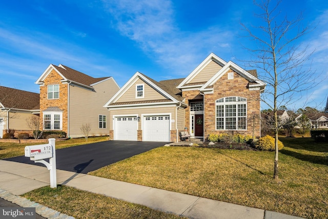 view of front of house featuring a garage, stone siding, a front yard, and driveway