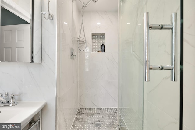 bathroom featuring a marble finish shower and vanity