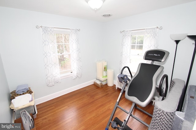 workout room with visible vents, baseboards, and wood finished floors