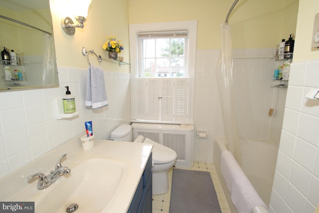 full bathroom with radiator, toilet, vanity, tile patterned floors, and tile walls