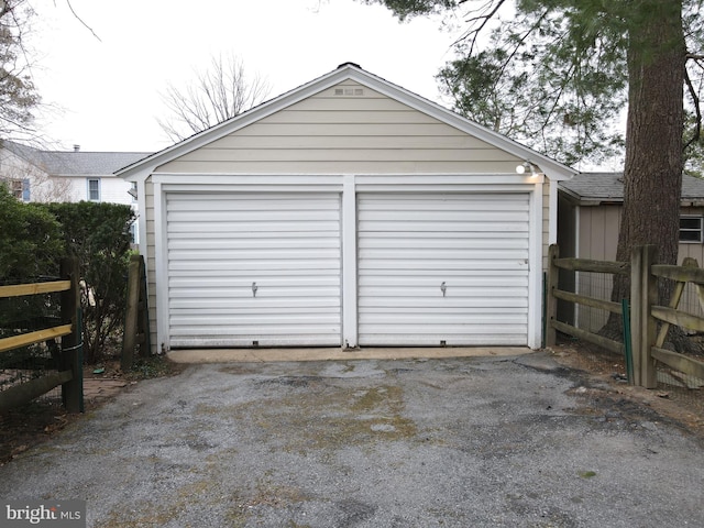 detached garage featuring fence