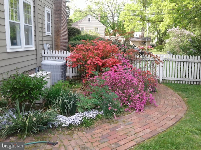 view of yard featuring central air condition unit and fence