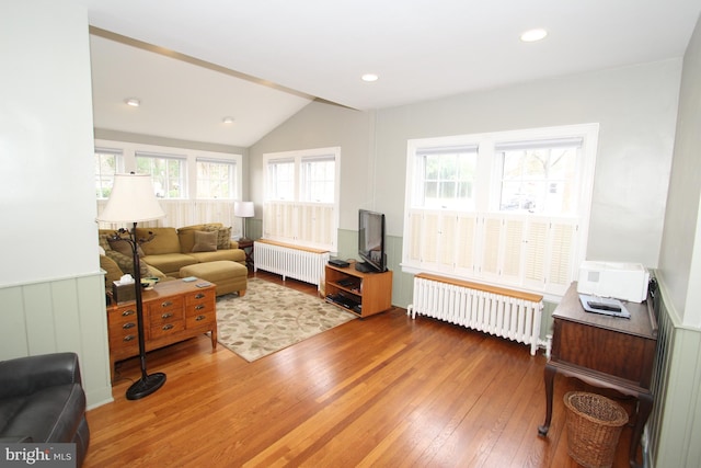 living room featuring recessed lighting, radiator, lofted ceiling, and wood-type flooring