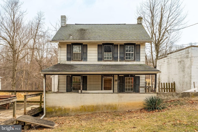 view of front facade featuring covered porch and a shingled roof