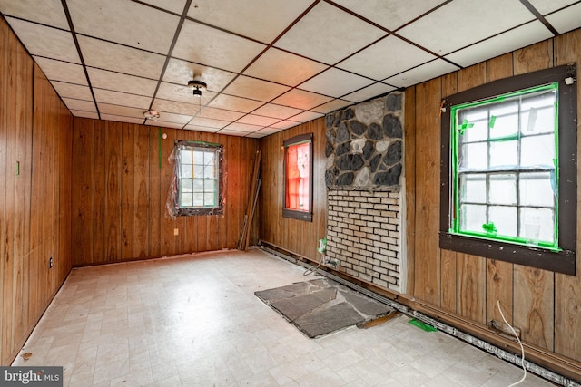 empty room with tile patterned floors and wooden walls