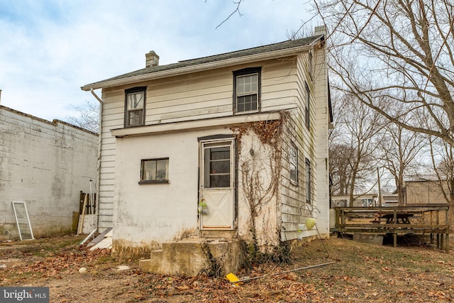 back of house featuring a chimney