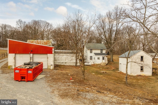 view of yard featuring a detached garage, an outbuilding, and driveway