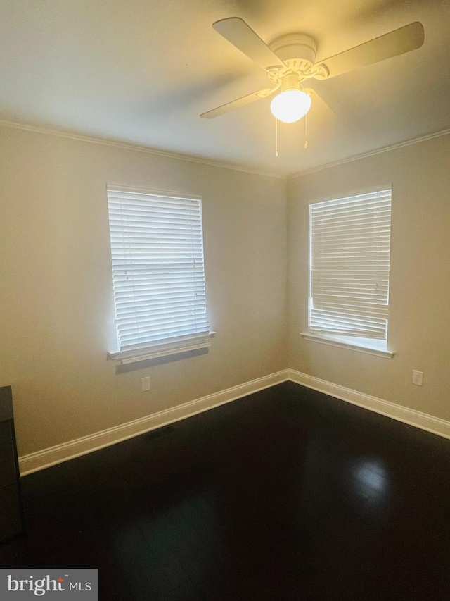 spare room featuring a wealth of natural light, a ceiling fan, and baseboards