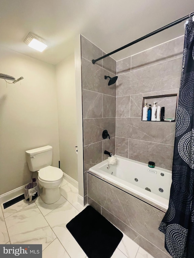 full bathroom featuring marble finish floor, toilet, baseboards, and tiled shower / bath