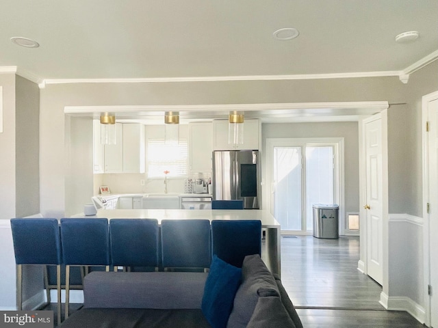 kitchen featuring dark wood-type flooring, ornamental molding, smart refrigerator, and white cabinetry