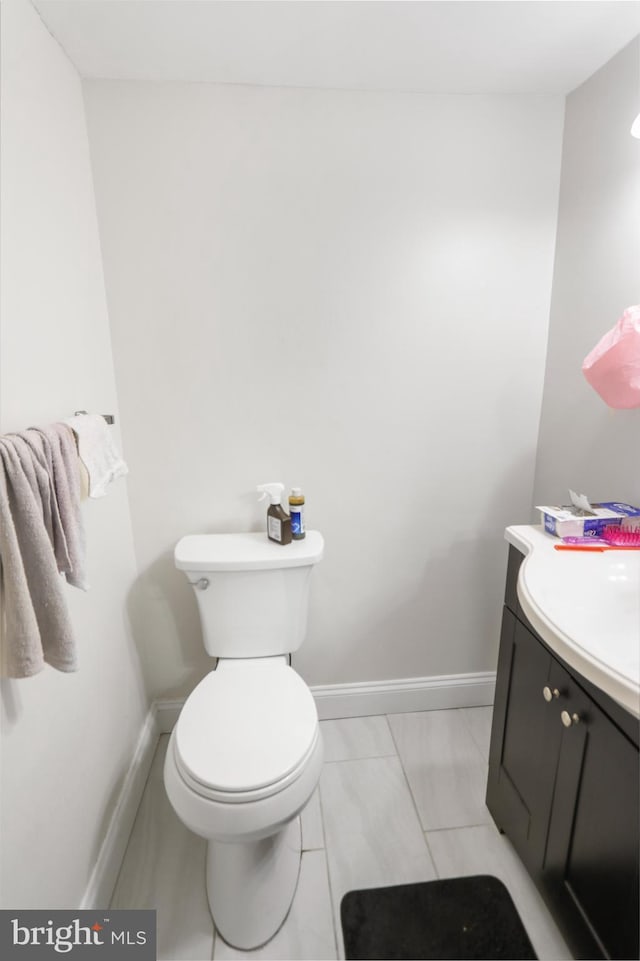 bathroom featuring vanity, toilet, and baseboards