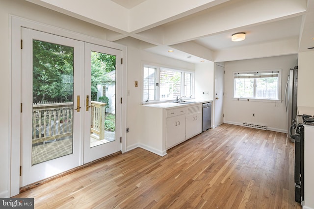 kitchen featuring visible vents, light wood finished floors, white cabinetry, stainless steel appliances, and light countertops