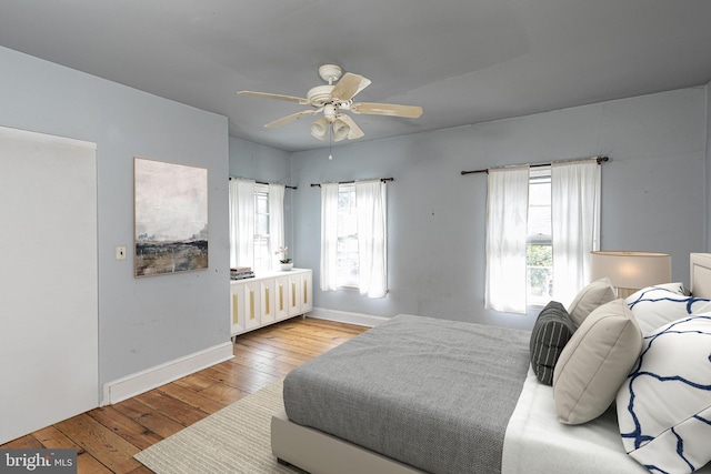 bedroom with ceiling fan, baseboards, and hardwood / wood-style floors