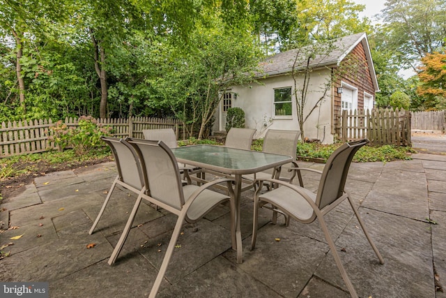 view of patio featuring outdoor dining space and fence