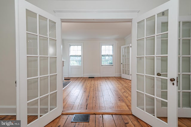 doorway featuring visible vents, ornamental molding, french doors, and wood-type flooring