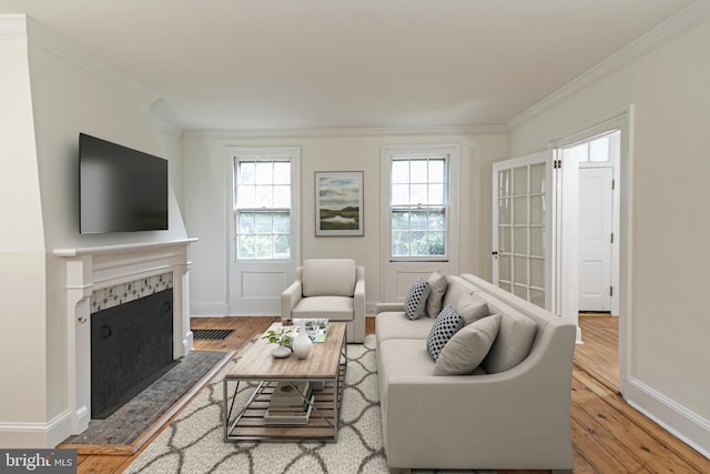 living area featuring a premium fireplace, wood-type flooring, and ornamental molding