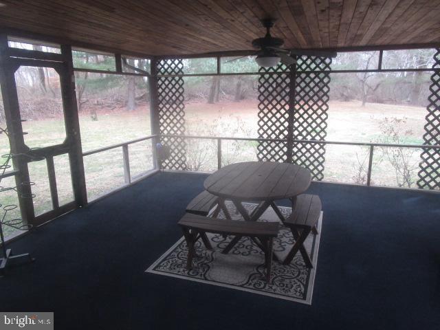 sunroom / solarium with ceiling fan and wooden ceiling