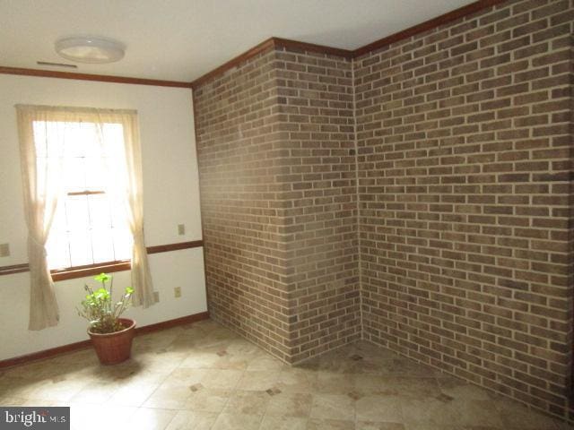 unfurnished room featuring baseboards and ornamental molding