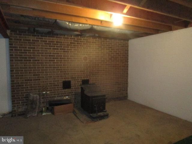 finished basement with brick wall and a wood stove