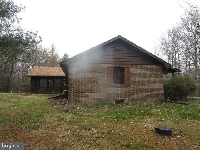 view of property exterior with a yard and brick siding