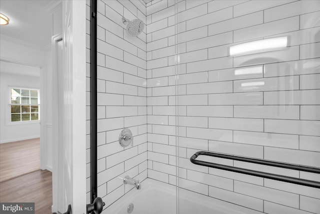 full bath featuring shower / washtub combination, wood finished floors, baseboards, and ornamental molding