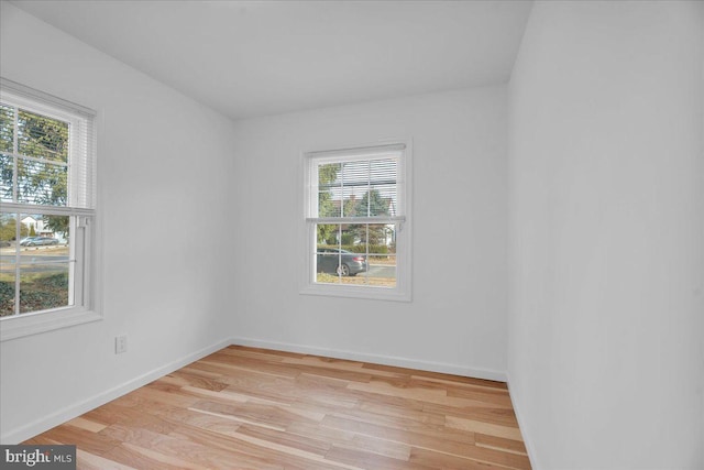 empty room featuring light wood-type flooring and baseboards