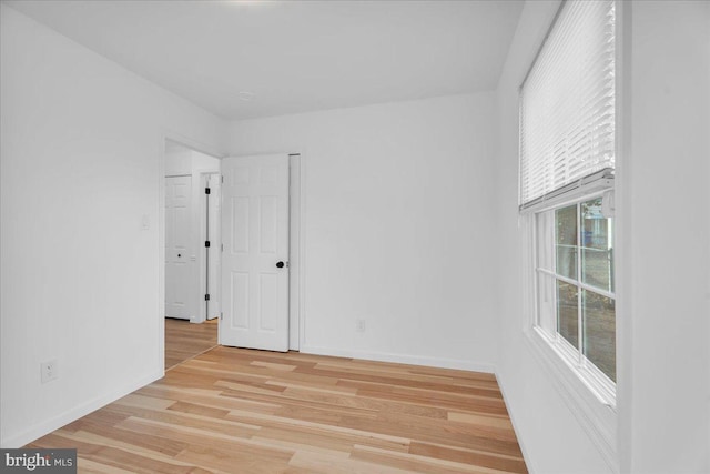 unfurnished room featuring light wood-style flooring and baseboards