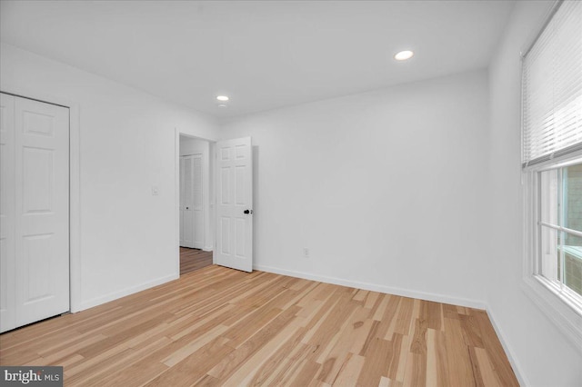 spare room with light wood-style flooring, recessed lighting, and baseboards