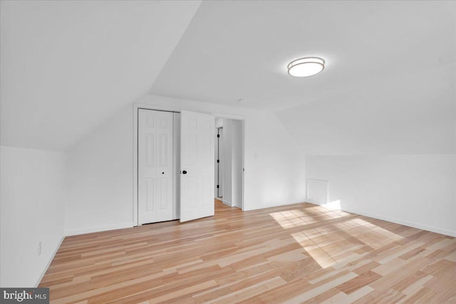 bonus room with vaulted ceiling, baseboards, and light wood finished floors