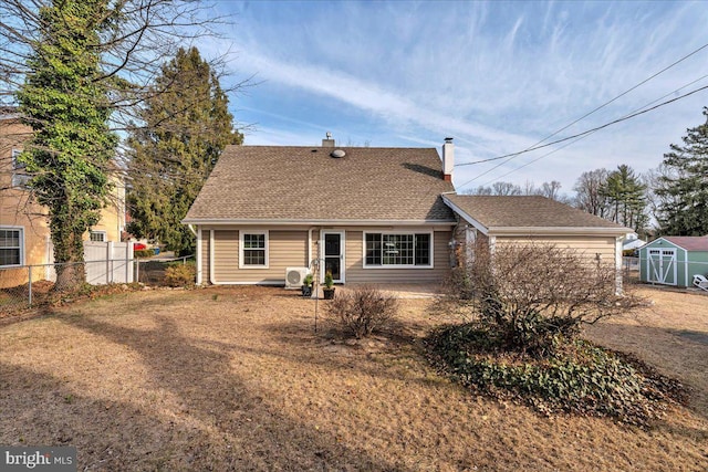 view of front of house with an outbuilding, a shingled roof, a chimney, and fence