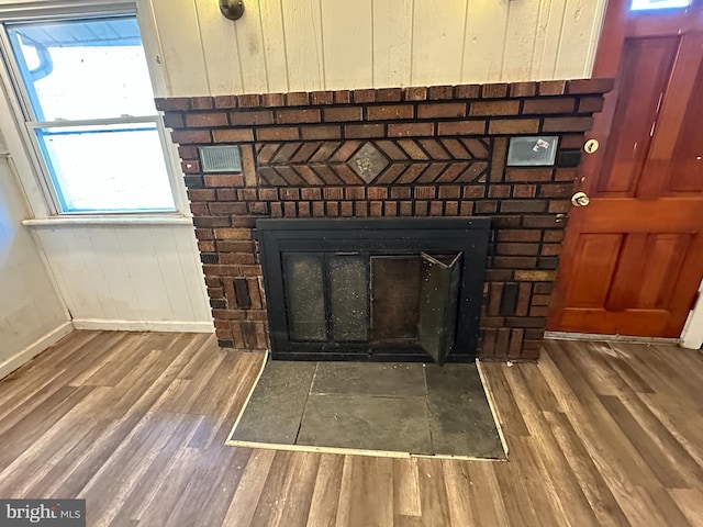 interior details with a fireplace, wood finished floors, and baseboards