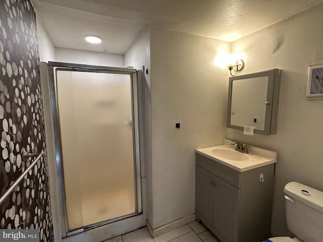 bathroom with vanity, a shower stall, and toilet