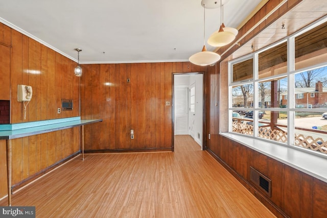 bar with visible vents, pendant lighting, wood finished floors, wooden walls, and crown molding