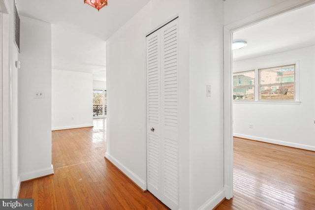 hall featuring baseboards and hardwood / wood-style floors