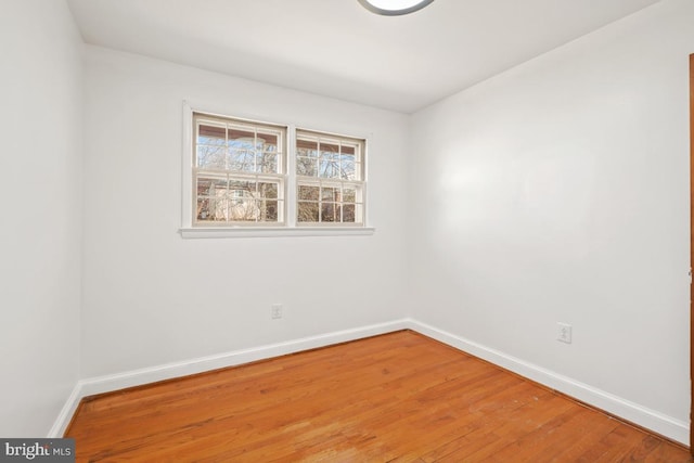 empty room with light wood finished floors and baseboards