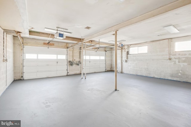 garage with concrete block wall and a garage door opener