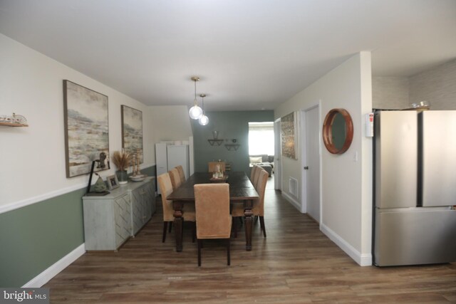 dining space with visible vents, wood finished floors, and baseboards