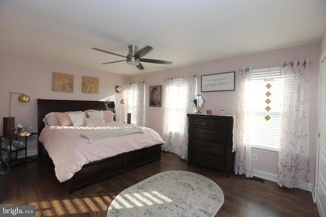 bedroom featuring baseboards, multiple windows, and dark wood-style flooring