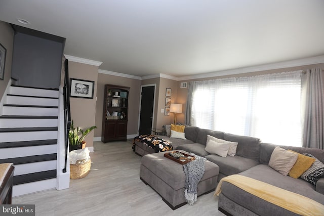 living room with visible vents, crown molding, baseboards, light wood-type flooring, and stairs