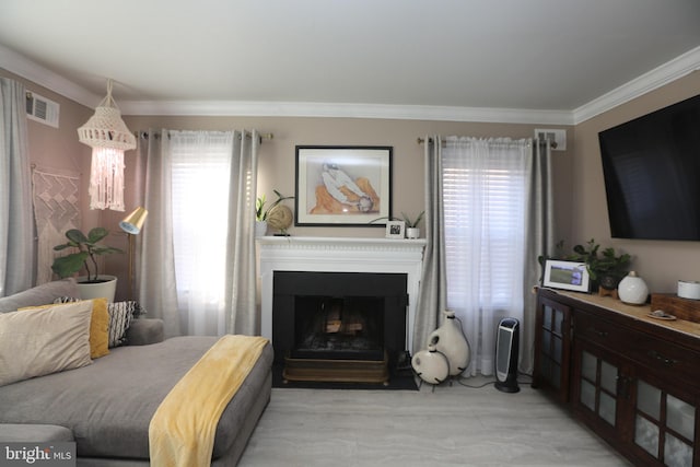 living room with visible vents, a fireplace, and crown molding