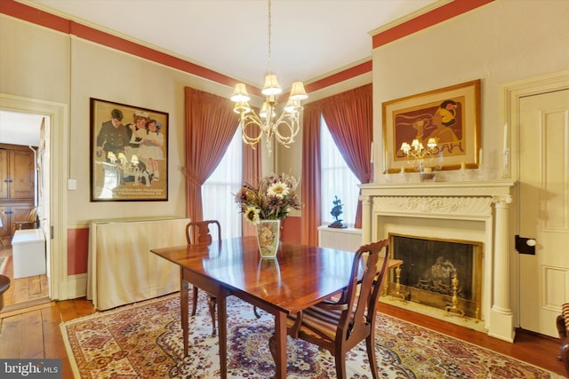 dining room with wallpapered walls, a fireplace with flush hearth, an inviting chandelier, and hardwood / wood-style flooring