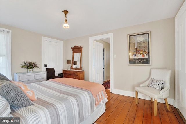 bedroom with baseboards and hardwood / wood-style flooring