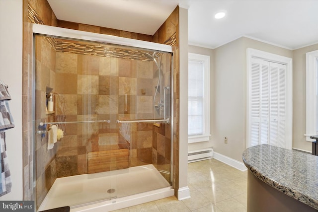 bathroom featuring tile patterned flooring, a baseboard heating unit, baseboards, ornamental molding, and a stall shower